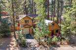 Nestled among tall pine trees, this charming property features a main house with a garage and a separate, cozy cabin.