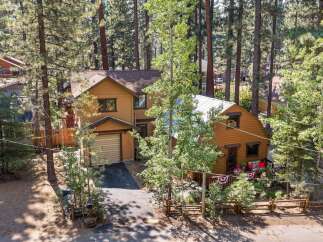 Nestled among tall pine trees, this charming property features a main house with a garage and a separate, cozy cabin.