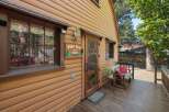 Charming cabin exterior featuring a rustic wooden door with a bear motif and a 'Pine Star Est.