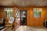 Step into this charming cabin featuring a cozy rocking chair adorned with a quilt, perfect for relaxing by the fireplace.