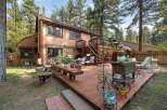 Enjoy outdoor living on this expansive wooden deck, perfect for entertaining or relaxing amidst a lush, wooded setting.
