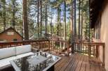 Enjoy the serene mountain lifestyle from this charming deck, perfect for outdoor living amidst tall pine trees.