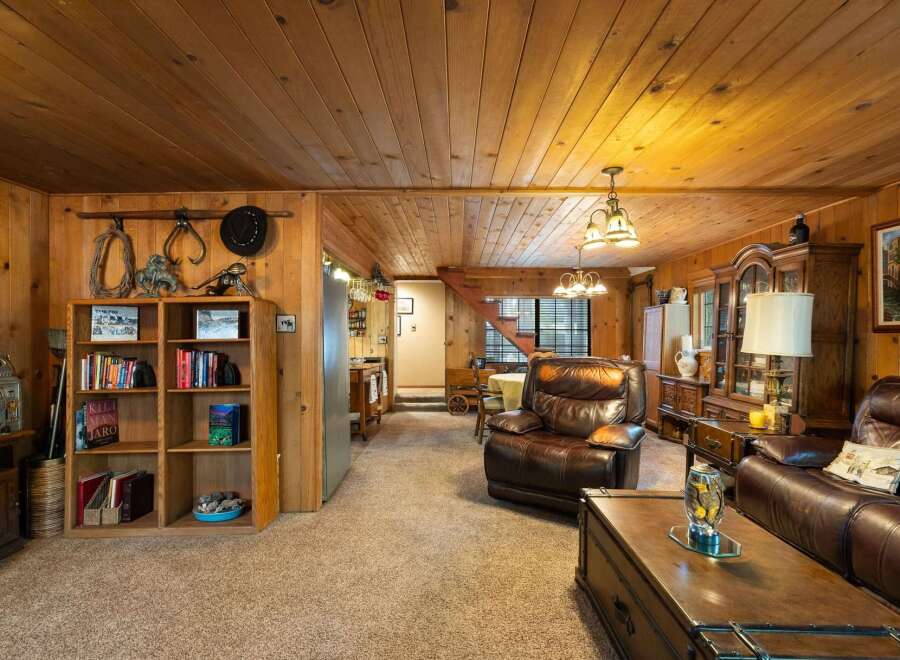 Step into a cozy living room featuring warm wood paneling and a plush, comfortable atmosphere.