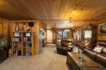 Step into a cozy living room featuring warm wood paneling and a plush, comfortable atmosphere.