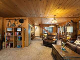 Step into a cozy living room featuring warm wood paneling and a plush, comfortable atmosphere.