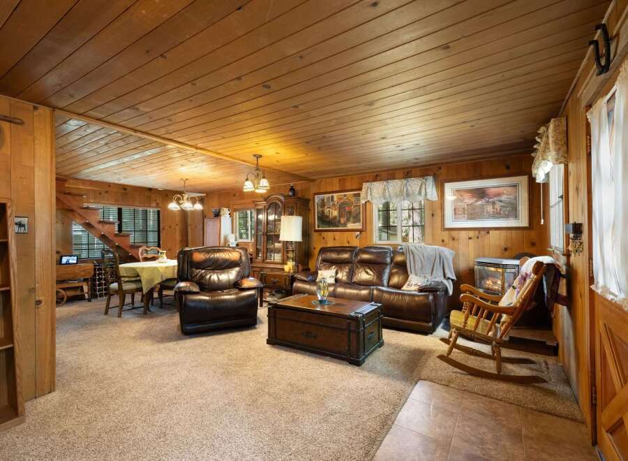 Step into this cozy cabin living room, featuring rich wood paneling and a warm, inviting atmosphere.