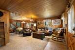 Step into this cozy cabin living room, featuring rich wood paneling and a warm, inviting atmosphere.