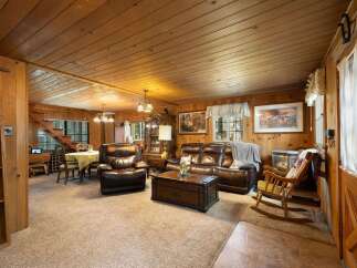 Step into this cozy cabin living room, featuring rich wood paneling and a warm, inviting atmosphere.