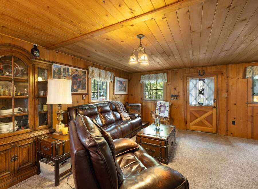 Step into a cozy cabin retreat featuring rich wood paneling throughout and a warm, inviting living area.