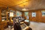 Step into a cozy cabin retreat featuring rich wood paneling throughout and a warm, inviting living area.