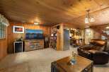 Step into this cozy living space featuring warm wood paneling and a large television perfect for movie nights.