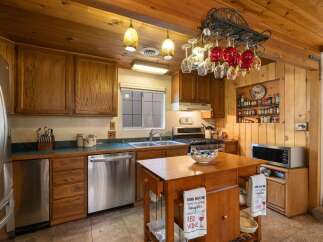 This charming kitchen boasts warm wooden cabinetry and a cozy, rustic aesthetic.