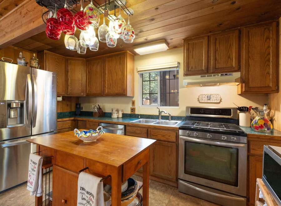 This charming kitchen features warm wooden cabinetry and a spacious stainless steel refrigerator.