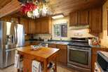 This charming kitchen features warm wooden cabinetry and a spacious stainless steel refrigerator.