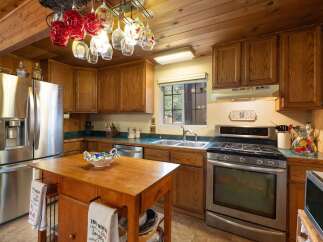 This charming kitchen features warm wooden cabinetry and a spacious stainless steel refrigerator.