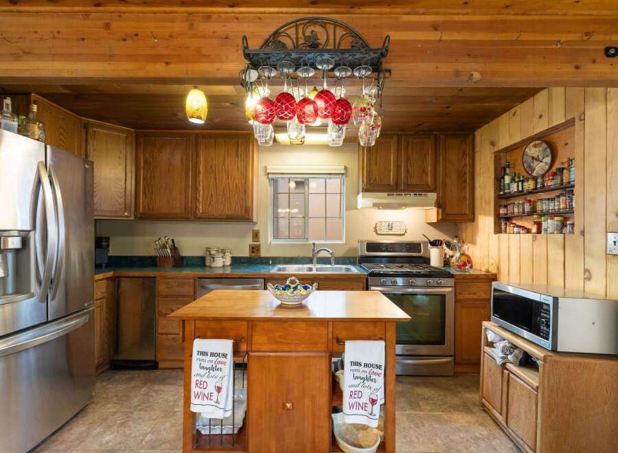 Experience rustic charm in this inviting kitchen featuring warm wooden cabinetry and exposed beams.