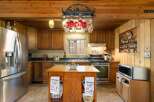 Experience rustic charm in this inviting kitchen featuring warm wooden cabinetry and exposed beams.