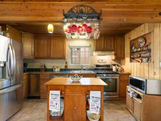 Experience rustic charm in this inviting kitchen featuring warm wooden cabinetry and exposed beams.