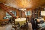 Step into a cozy dining area featuring a charming wooden staircase and a warm, inviting atmosphere.