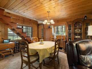 Step into a cozy dining area featuring a charming wooden staircase and a warm, inviting atmosphere.