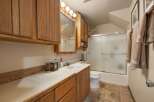This bathroom features a spacious vanity with ample storage, complemented by warm wooden cabinetry.
