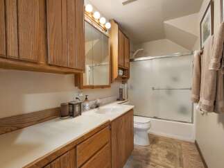 This bathroom features a spacious vanity with ample storage, complemented by warm wooden cabinetry.