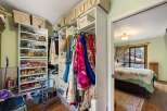 Discover ample storage in this well-organized walk-in closet, featuring multiple shelves for shoes and hanging racks for clothing.