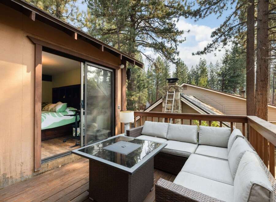 Enjoy outdoor living on this spacious deck, perfect for entertaining or relaxing amidst the serene forest setting.