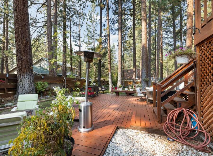 Enjoy outdoor living in this spacious backyard featuring a large wooden deck perfect for entertaining.