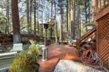 Enjoy outdoor living in this spacious backyard featuring a large wooden deck perfect for entertaining.