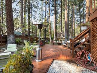 Enjoy outdoor living in this spacious backyard featuring a large wooden deck perfect for entertaining.