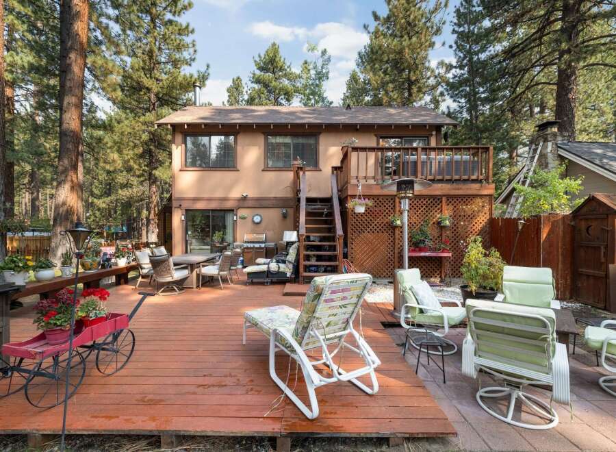 Enjoy outdoor living in this spacious backyard featuring a large wooden deck perfect for entertaining.