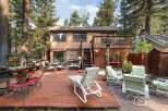 Enjoy outdoor living in this spacious backyard featuring a large wooden deck perfect for entertaining.