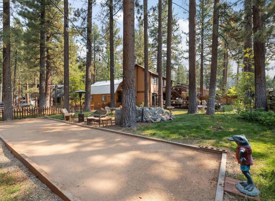 Enjoy outdoor recreation with a dedicated bocce ball court set amidst a serene, wooded landscape.