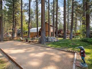Enjoy outdoor recreation with a dedicated bocce ball court set amidst a serene, wooded landscape.