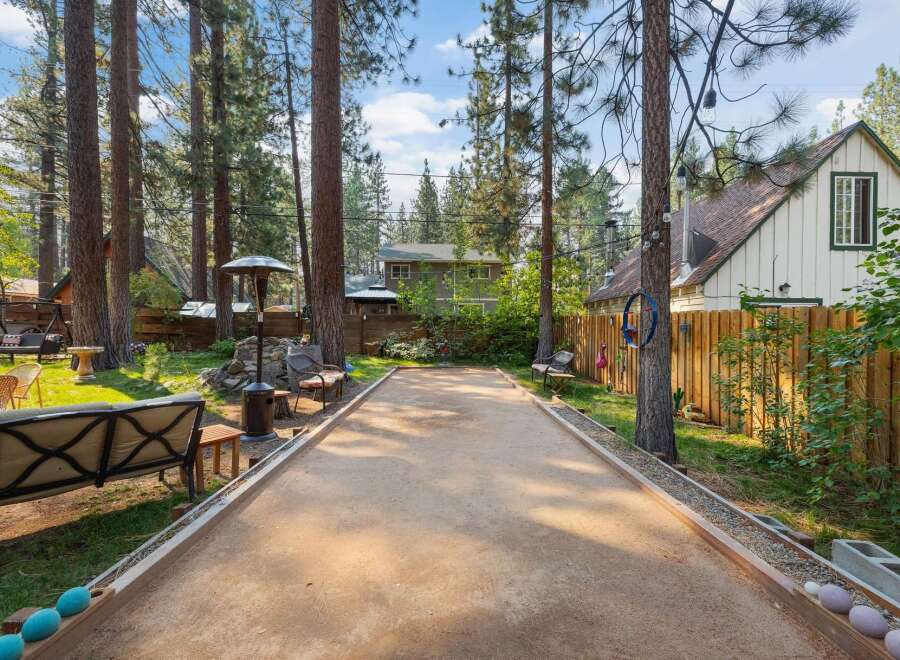 Enjoy outdoor fun in this charming backyard featuring a bocce ball court perfect for friendly competition.