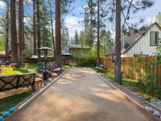 Enjoy outdoor fun in this charming backyard featuring a bocce ball court perfect for friendly competition.
