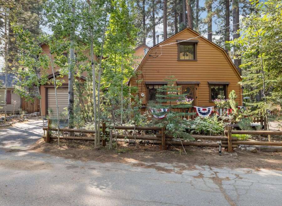 Charming rustic cabin nestled amongst tall pine trees, offering a serene mountain getaway.