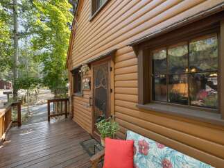 Charming log cabin nestled amongst tall trees, offering a rustic retreat.