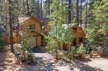 Nestled amongst tall pine trees, this charming mountain home offers a serene escape.