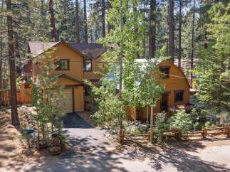 Nestled amongst tall pine trees, this charming mountain home offers a serene escape.