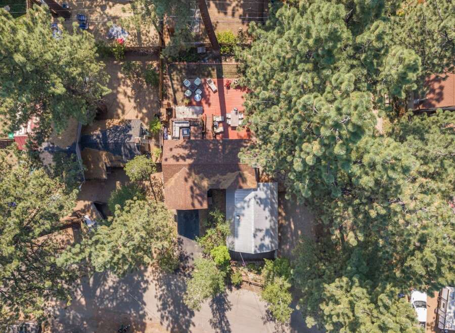 Discover this charming property featuring a spacious wooden deck perfect for outdoor entertaining, complete with comfortable seating and a dining area.