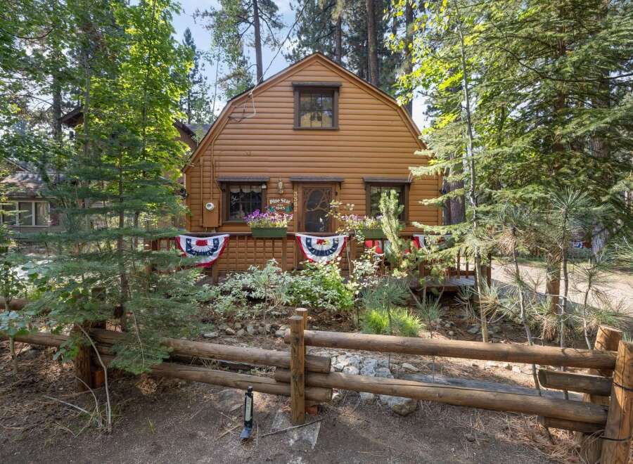 Charming rustic cabin nestled amongst tall pine trees, offering a serene mountain getaway.