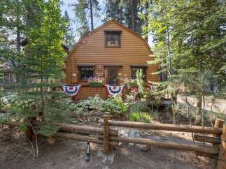 Charming rustic cabin nestled amongst tall pine trees, offering a serene mountain getaway.