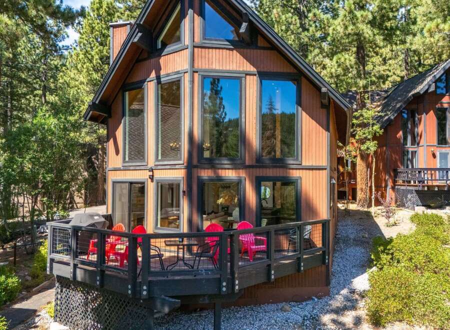 Experience mountain living in this charming cabin featuring a spacious wooden deck perfect for outdoor entertaining.