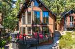 Experience mountain living in this charming cabin featuring a spacious wooden deck perfect for outdoor entertaining.