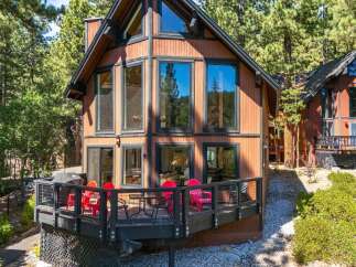 Experience mountain living in this charming cabin featuring a spacious wooden deck perfect for outdoor entertaining.