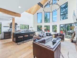 Experience modern mountain living in this stunning open-concept home, featuring a gourmet kitchen with a large island and sleek cabinetry.