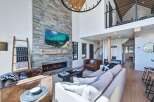 Experience luxury living in this stunning modern mountain home, featuring a soaring stone fireplace as the centerpiece of the open-concept living area.