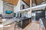 Experience luxury mountain living in this stunning open-concept home featuring a soaring vaulted ceiling with exposed wood beams and a magnificent floor-to-ceiling stone fireplace.